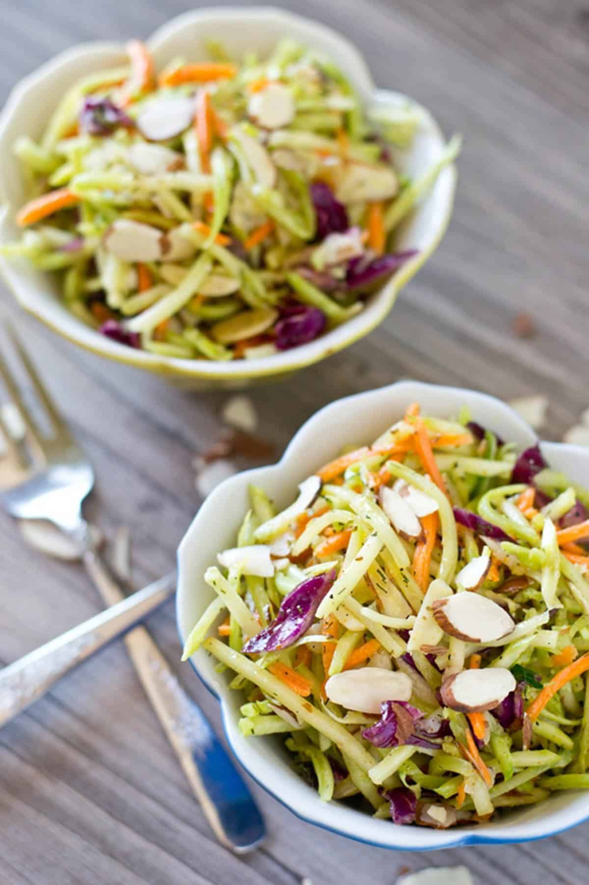 two bowls of broccoli slaw on a table