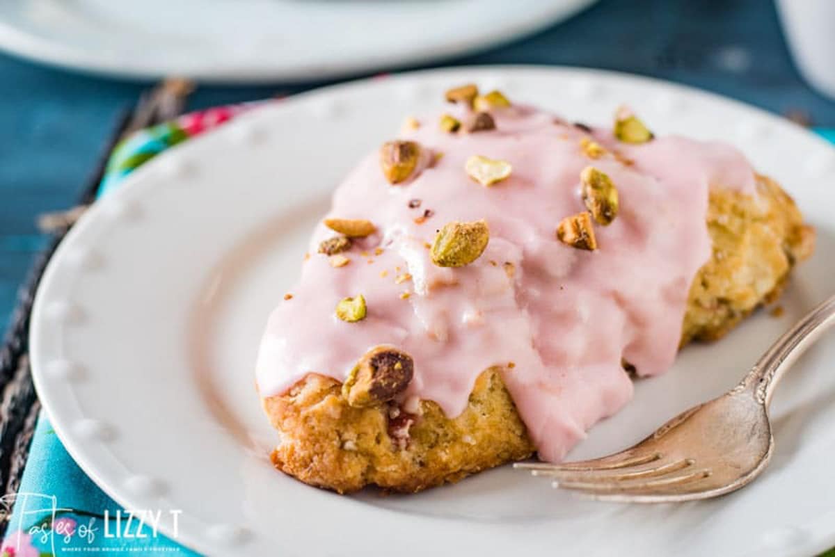 a glazed cherry scone on a plate with a fork