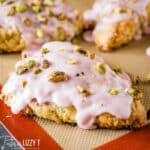 buttermilk cherry scones with glaze and pistachios on a pastry mat