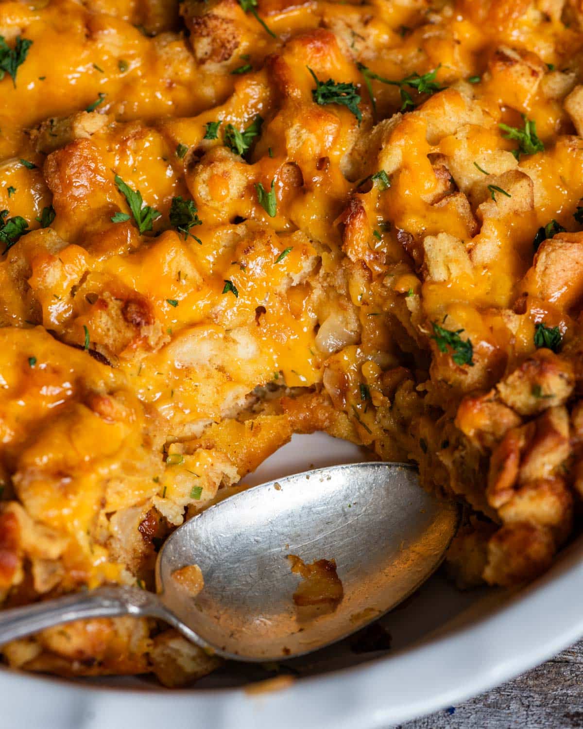 cheddar herb stuffing in a baking dish with a spoon