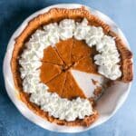 overhead view of christmas pumpkin pie with one slice missing