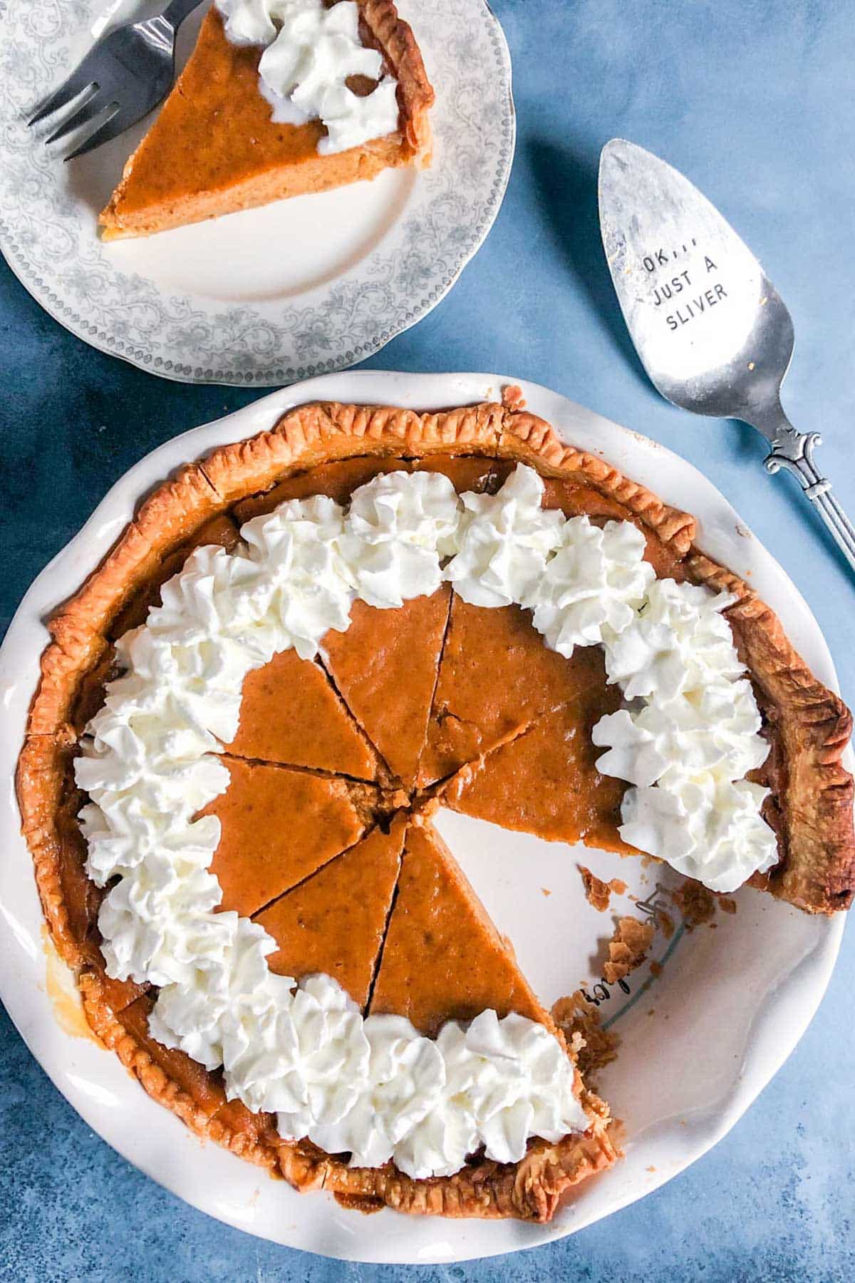 christmas pumpkin pie on a table with one slice out