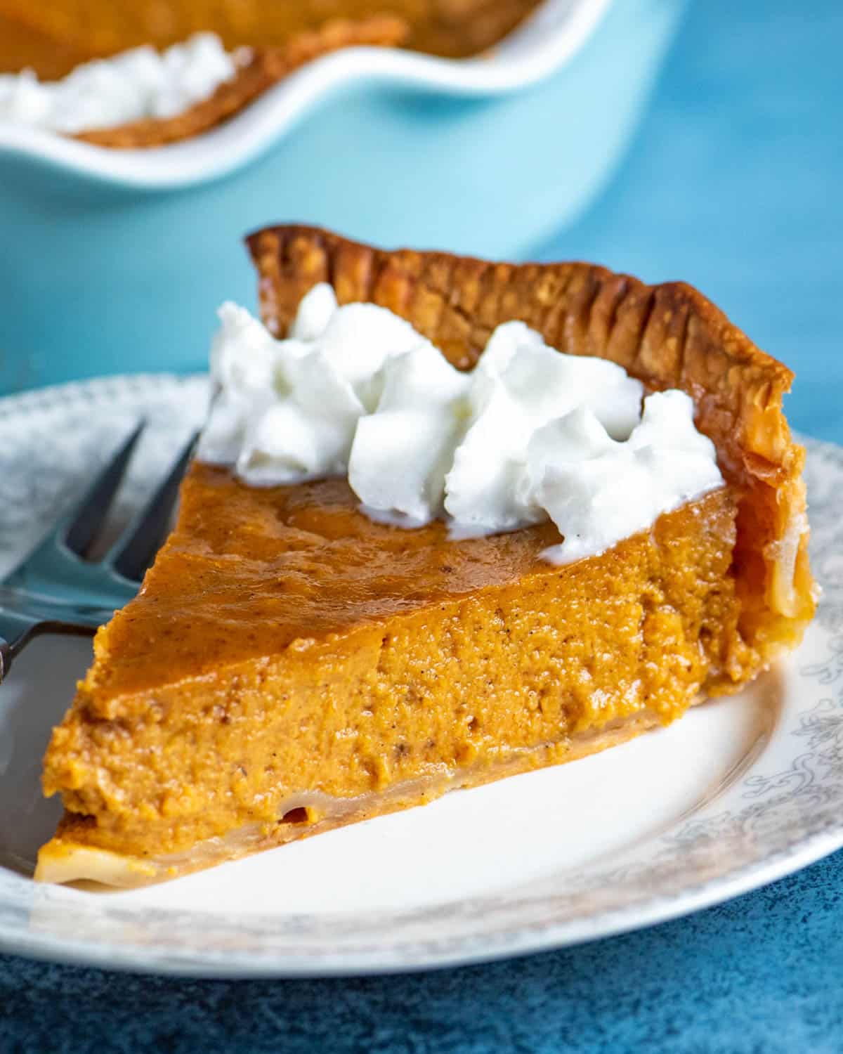 a slice of pumpkin pie with eggnog on a table