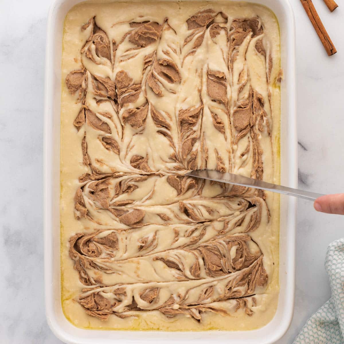 knife swirling cinnamon into cake batter