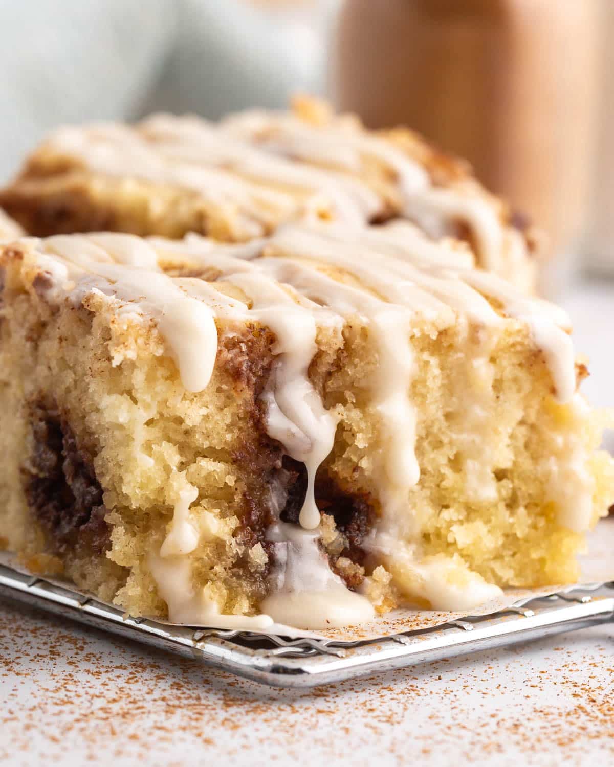 a piece of cinnamon roll cake with dripping glaze