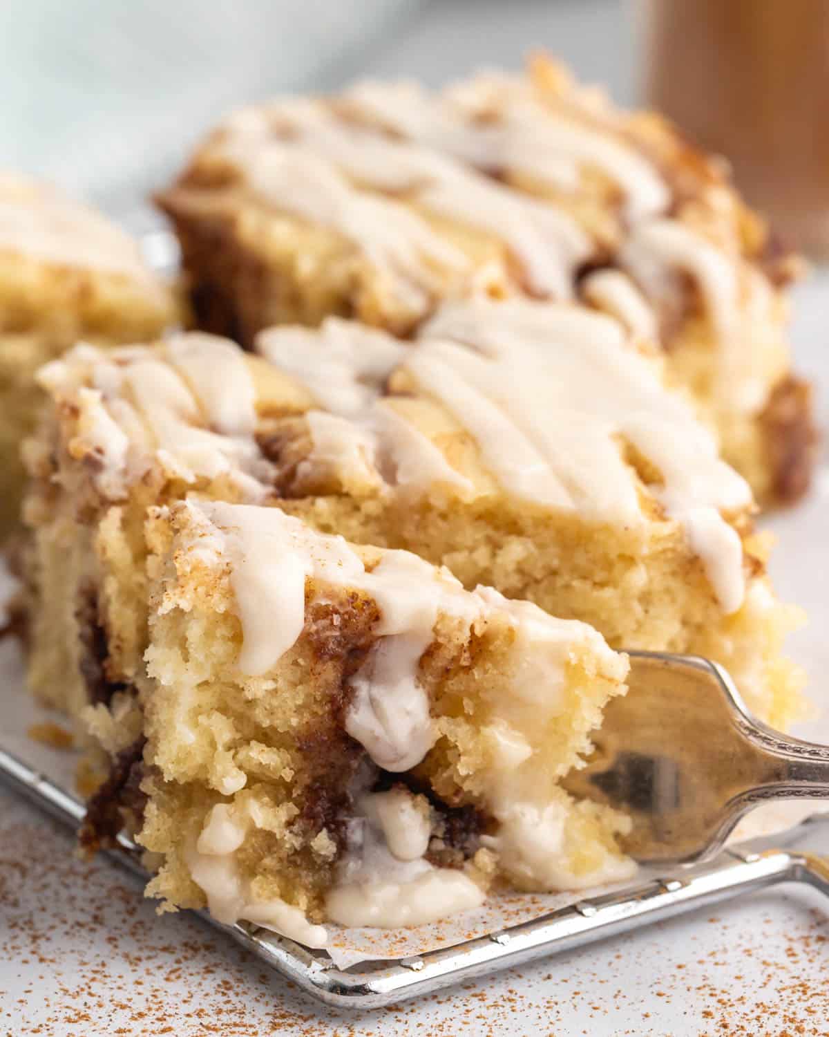 a fork cutting into a piece of cinnamon roll cake