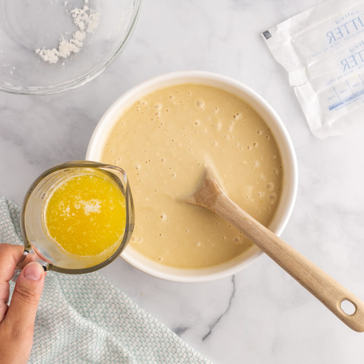 pouring melted butter into cake mix