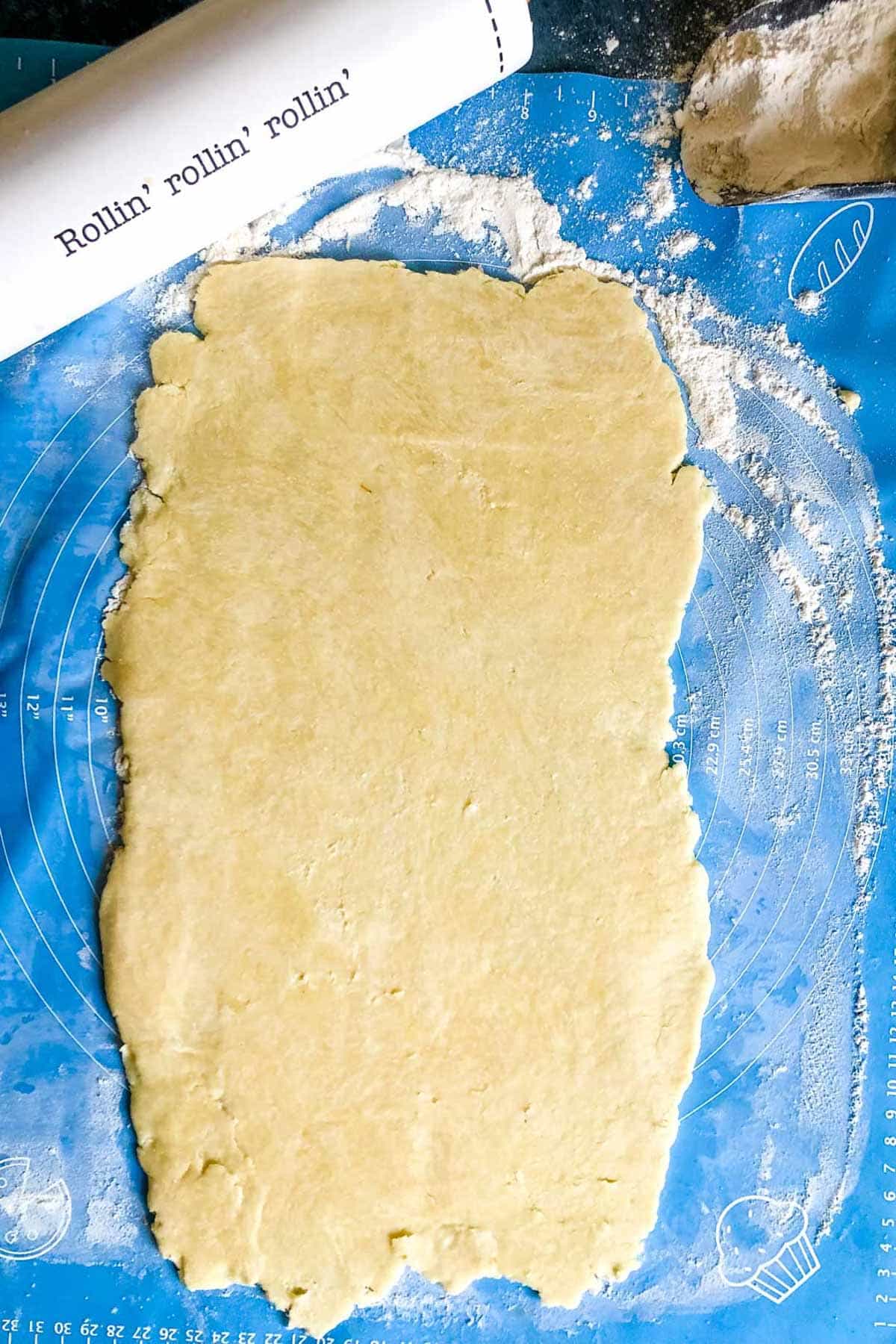 pie dough rolled out on a pastry mat