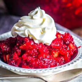 a bowl of cranberry orange jello salad with whipped cream