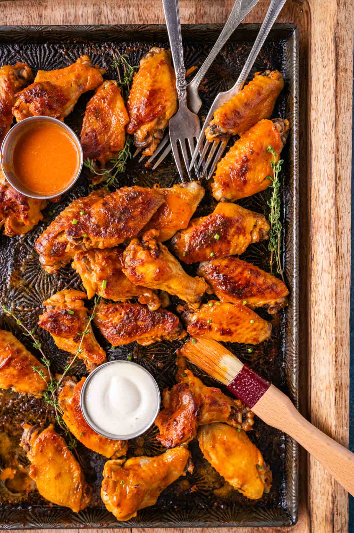 buffalo chicken wings on a pan with ranch and buffalo sauce