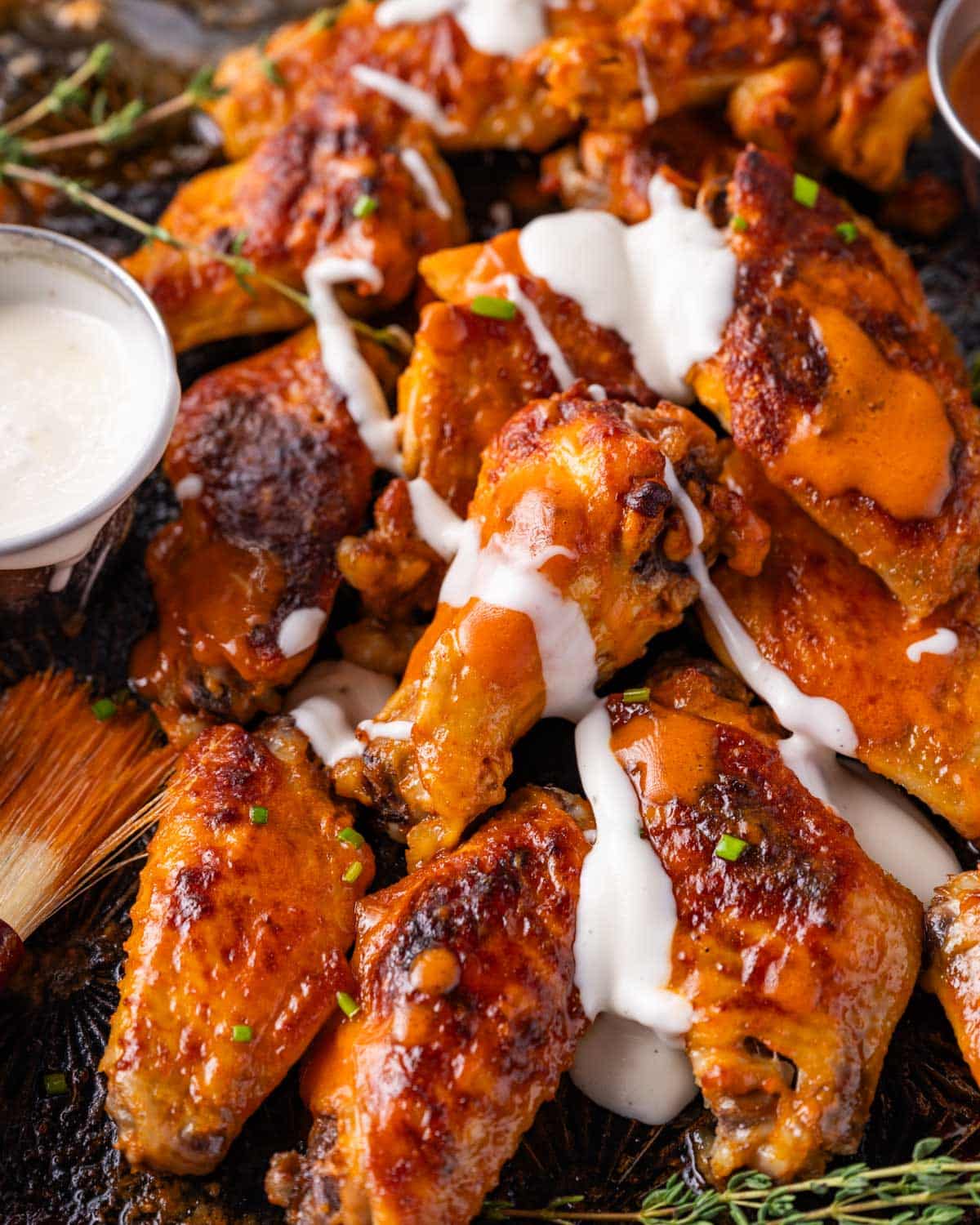 closeup of buffalo wings with ranch drizzled on top