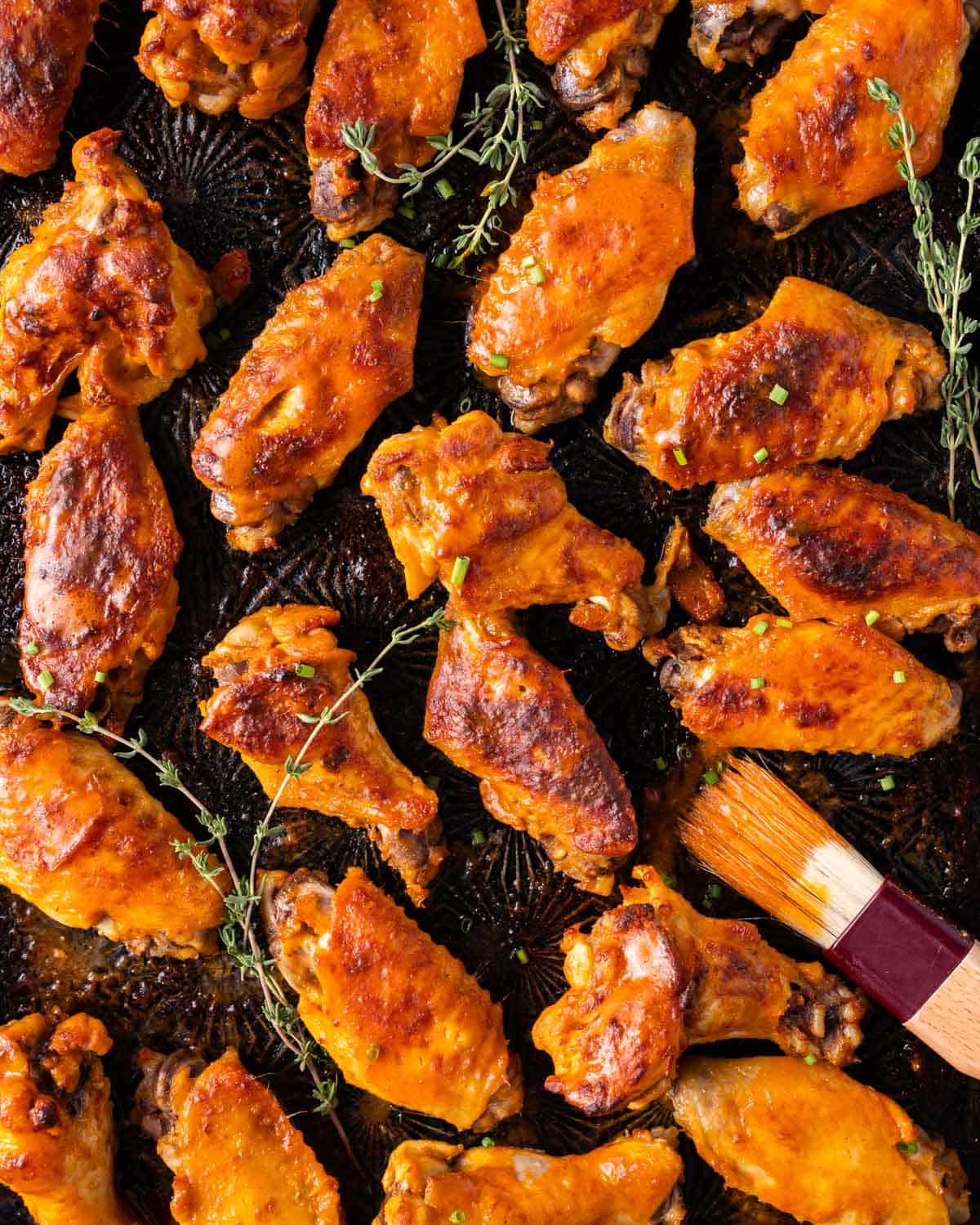 buffalo chicken wings on a pan with fresh thyme