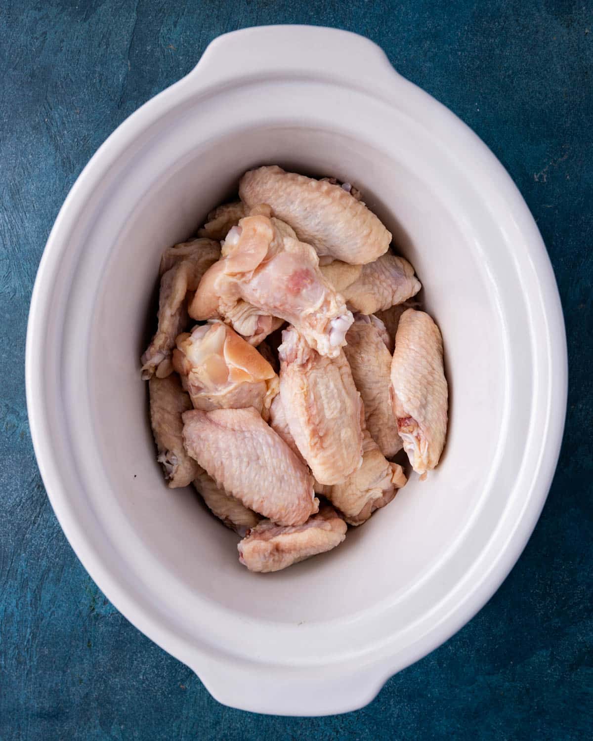 uncooked chicken wings in a crockpot