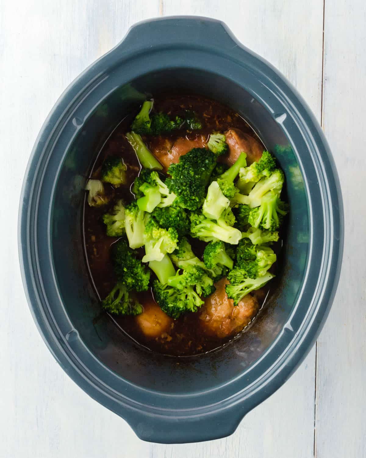 broccoli over cooked chicken in a crockpot