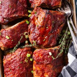 pork ribs on a pan with fresh thyme and green onions