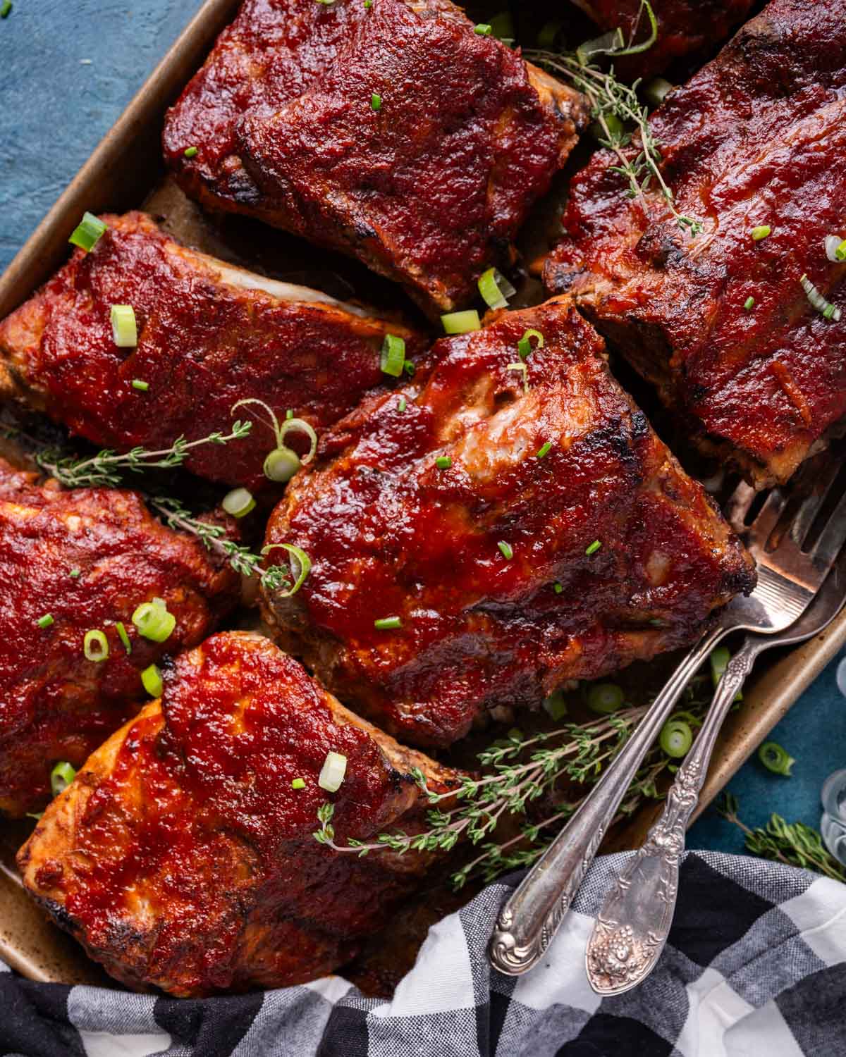 pork ribs on a pan with fresh thyme and green onions