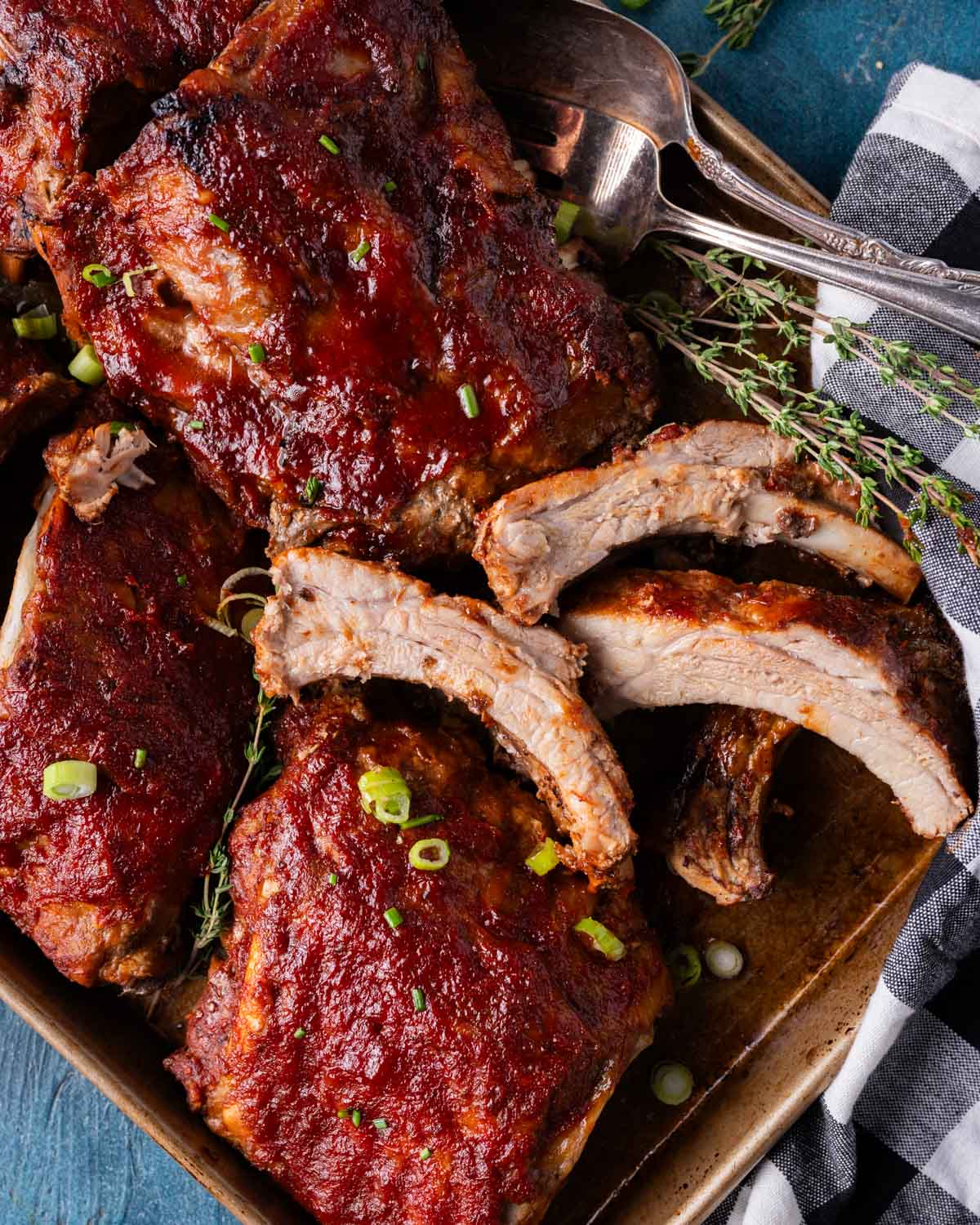 closeup of pork ribs on a pan, one cut into pieces