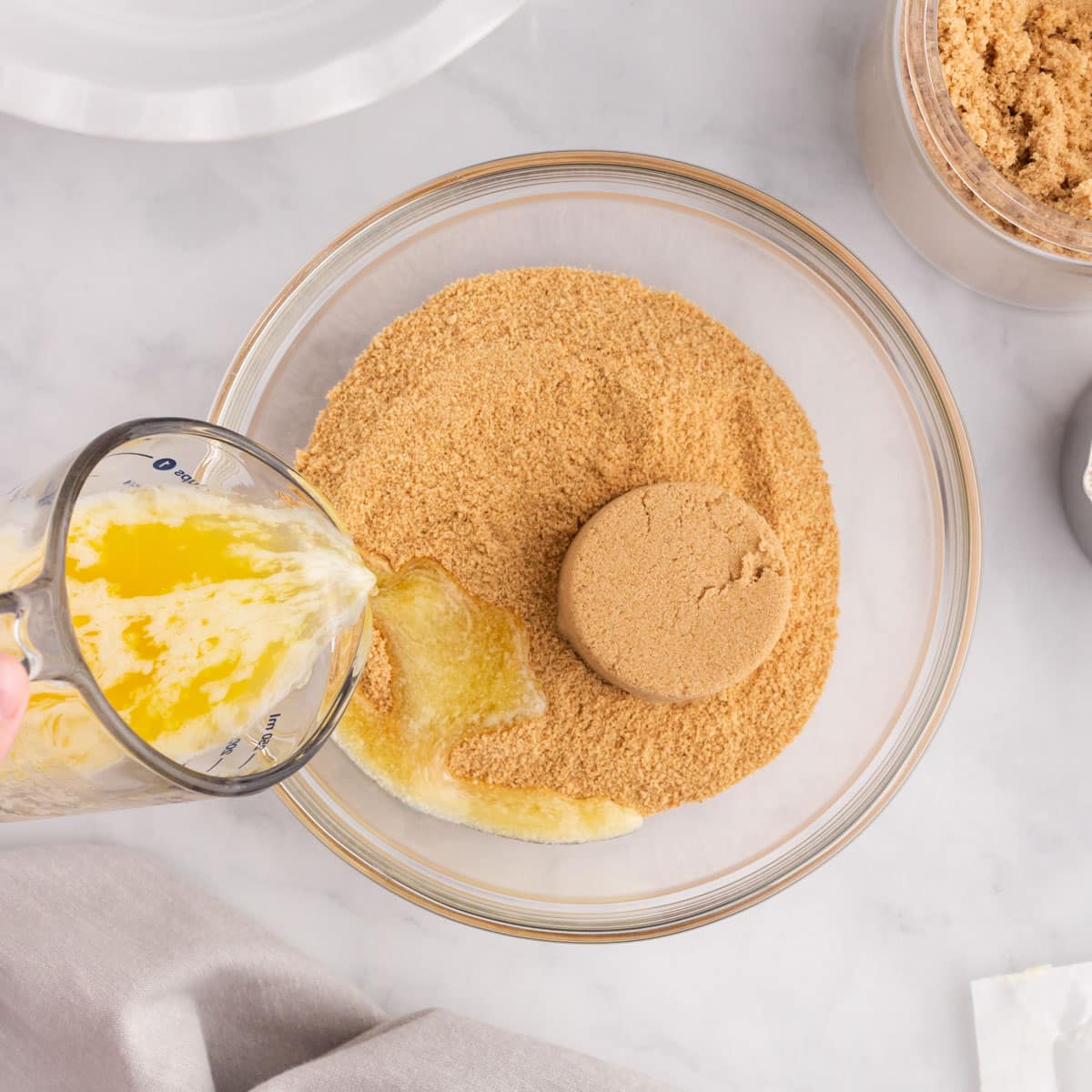 a bowl with graham cracker crumbs, brown sugar and butter