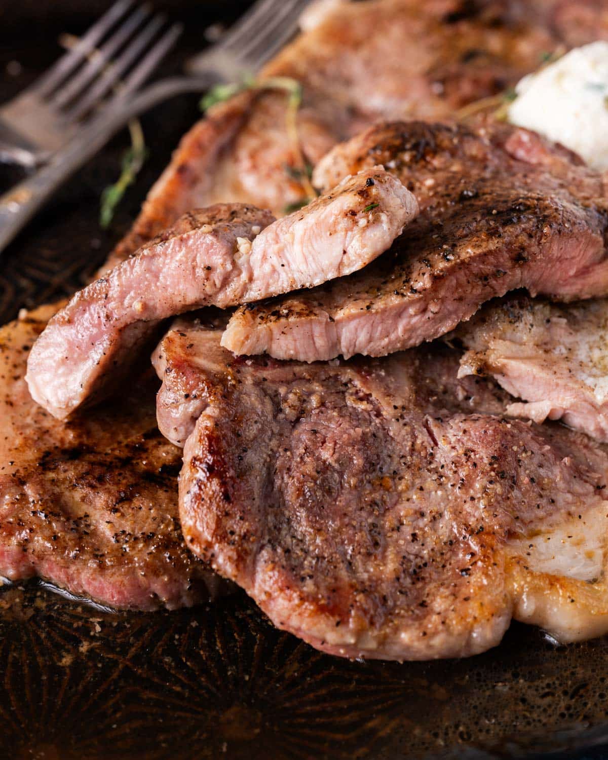 pork steaks cut in half on a pan