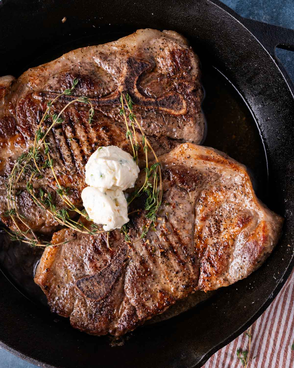 overhead view of pork steaks in a cast iron skillet