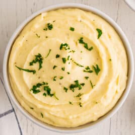 closeup of a bowl of instant mashed potatoes with fresh parsley on top