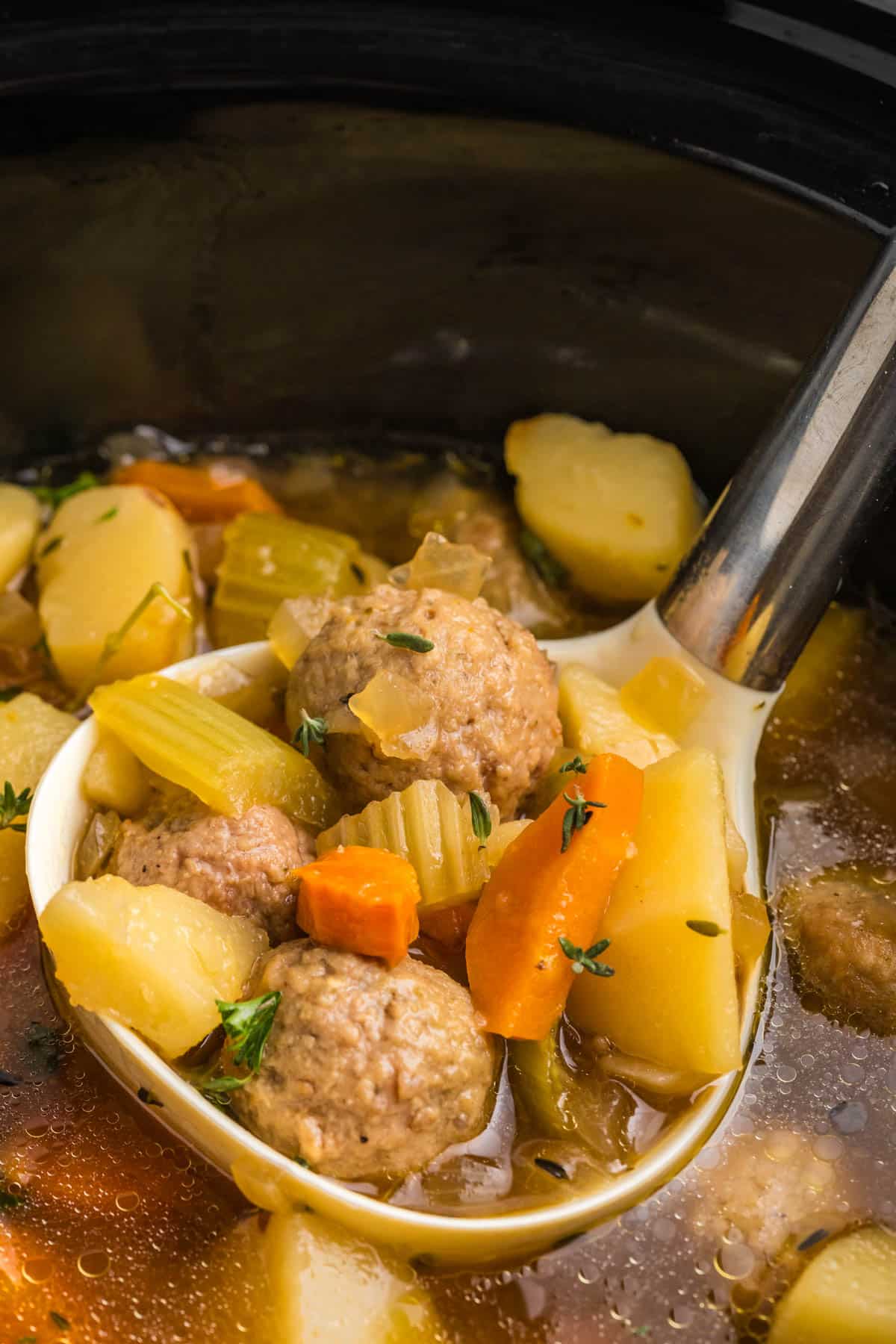 meatballs with potatoes and vegetables on a ladle