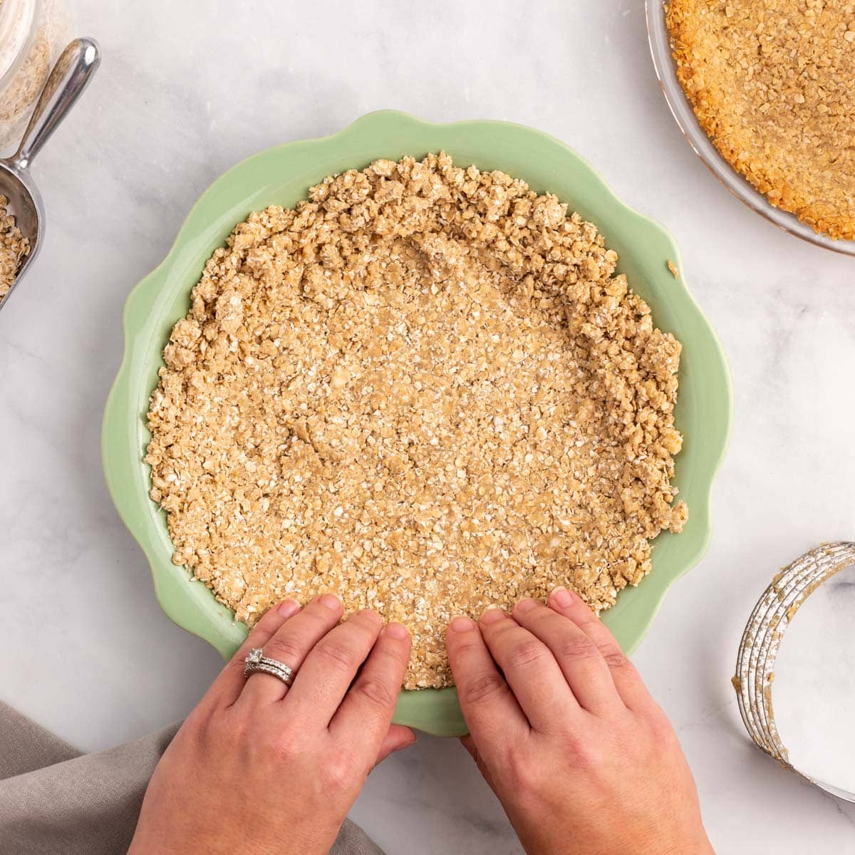 pressing oatmeal pie crust in a pan