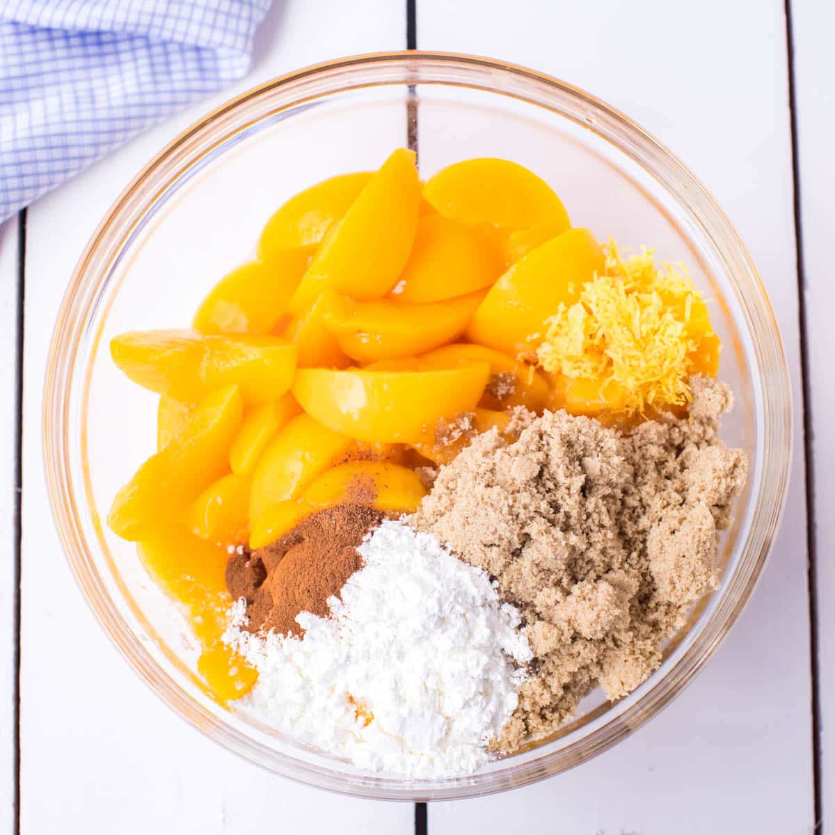 peaches, sugars, cornstarch, cinnamon and lemon in a bowl