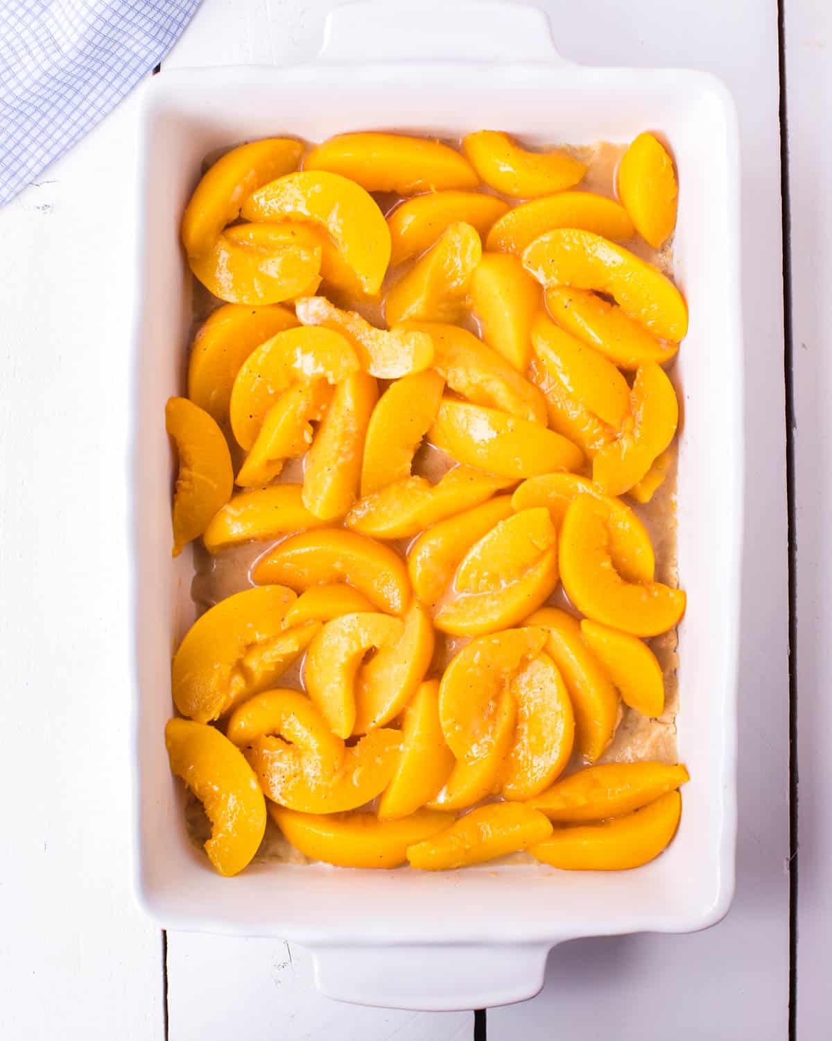 canned peaches layered in a baking pan