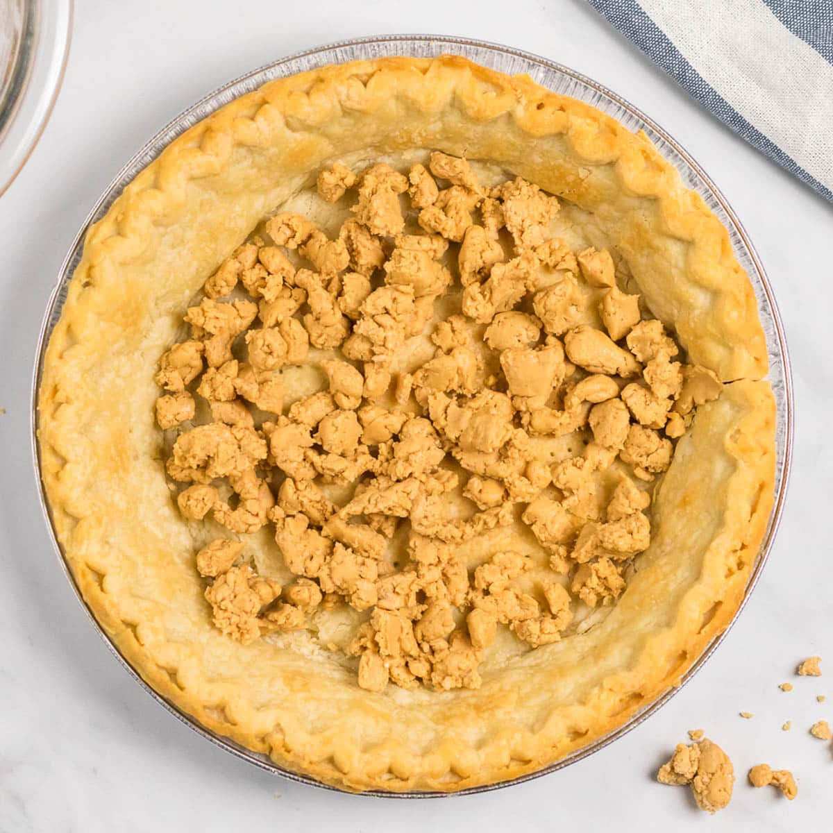 peanut butter crumbles inside of a baked pie shell