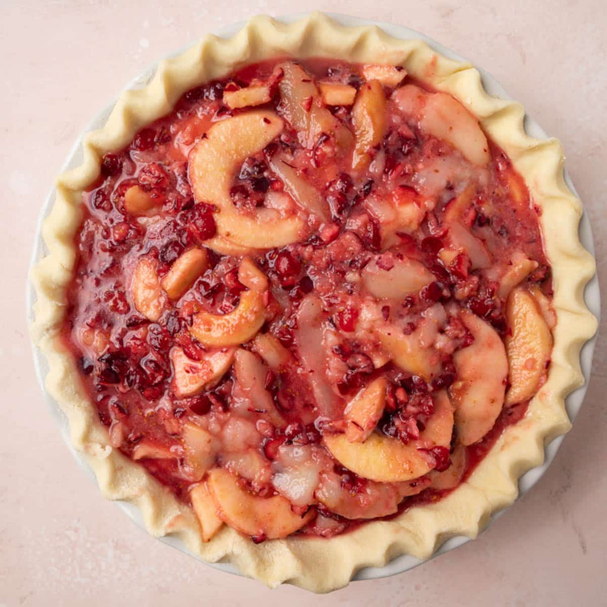 overhead view of unbaked pear cranberry pie