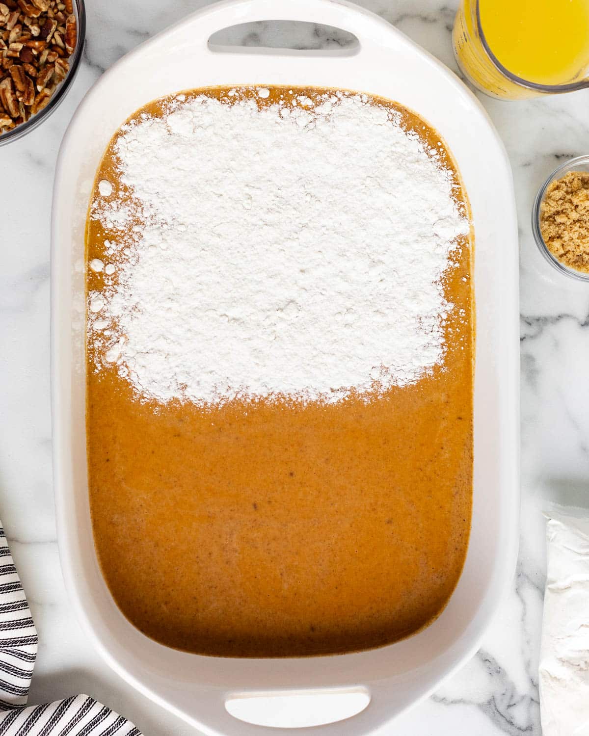 dry cake mix over pumpkin filling in a baking pan