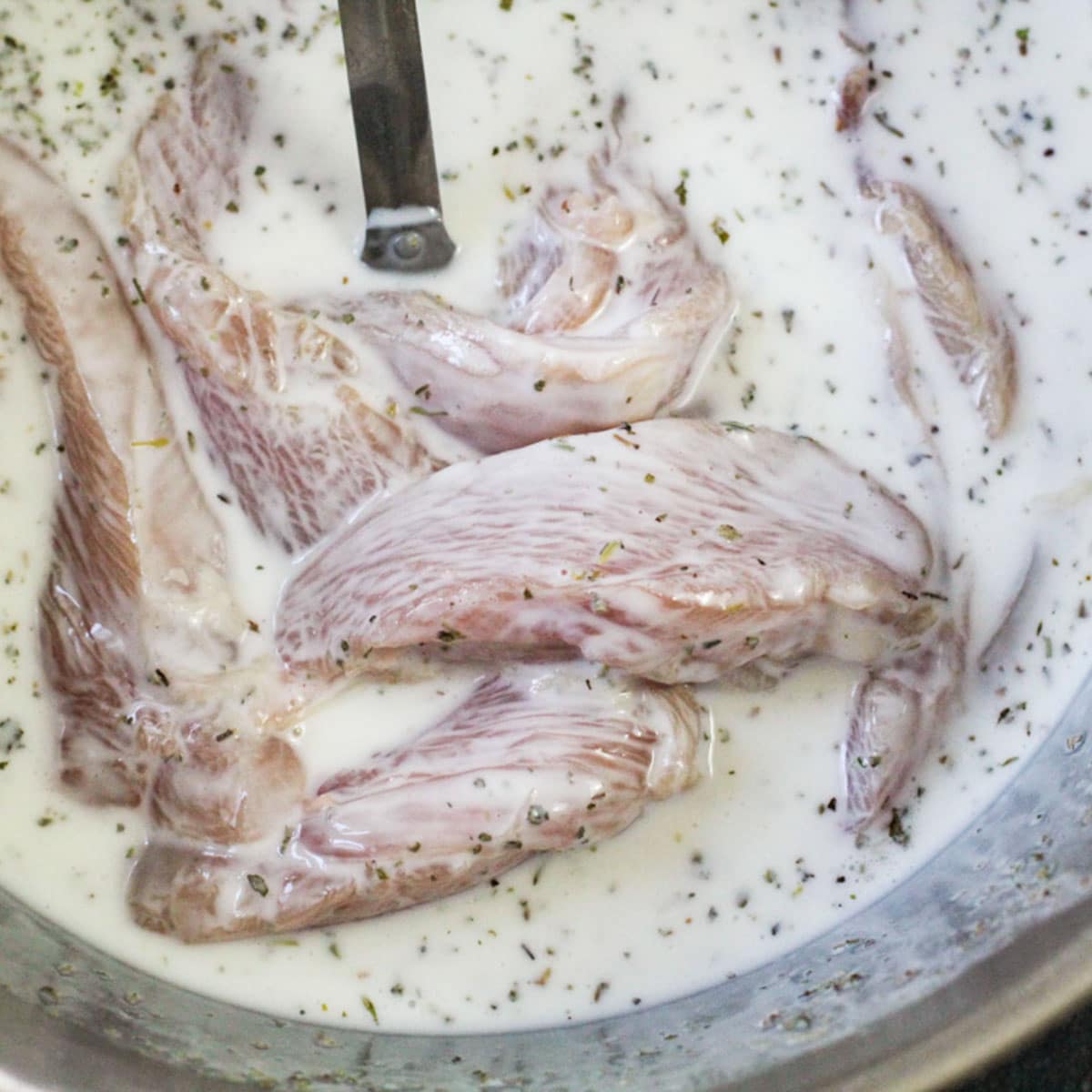 chicken marinating in herbed buttermilk