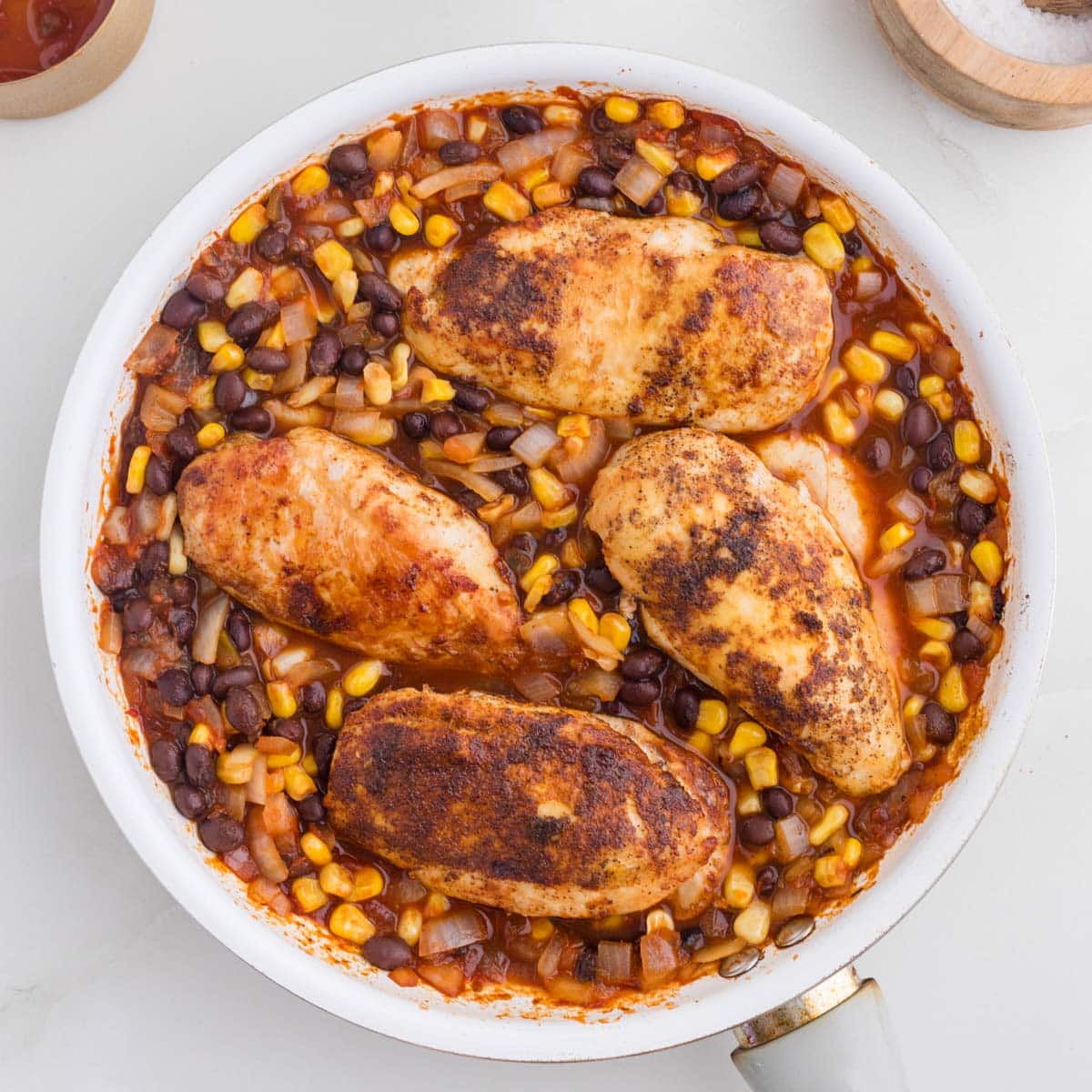 chicken with beans, corn and onions in a skillet