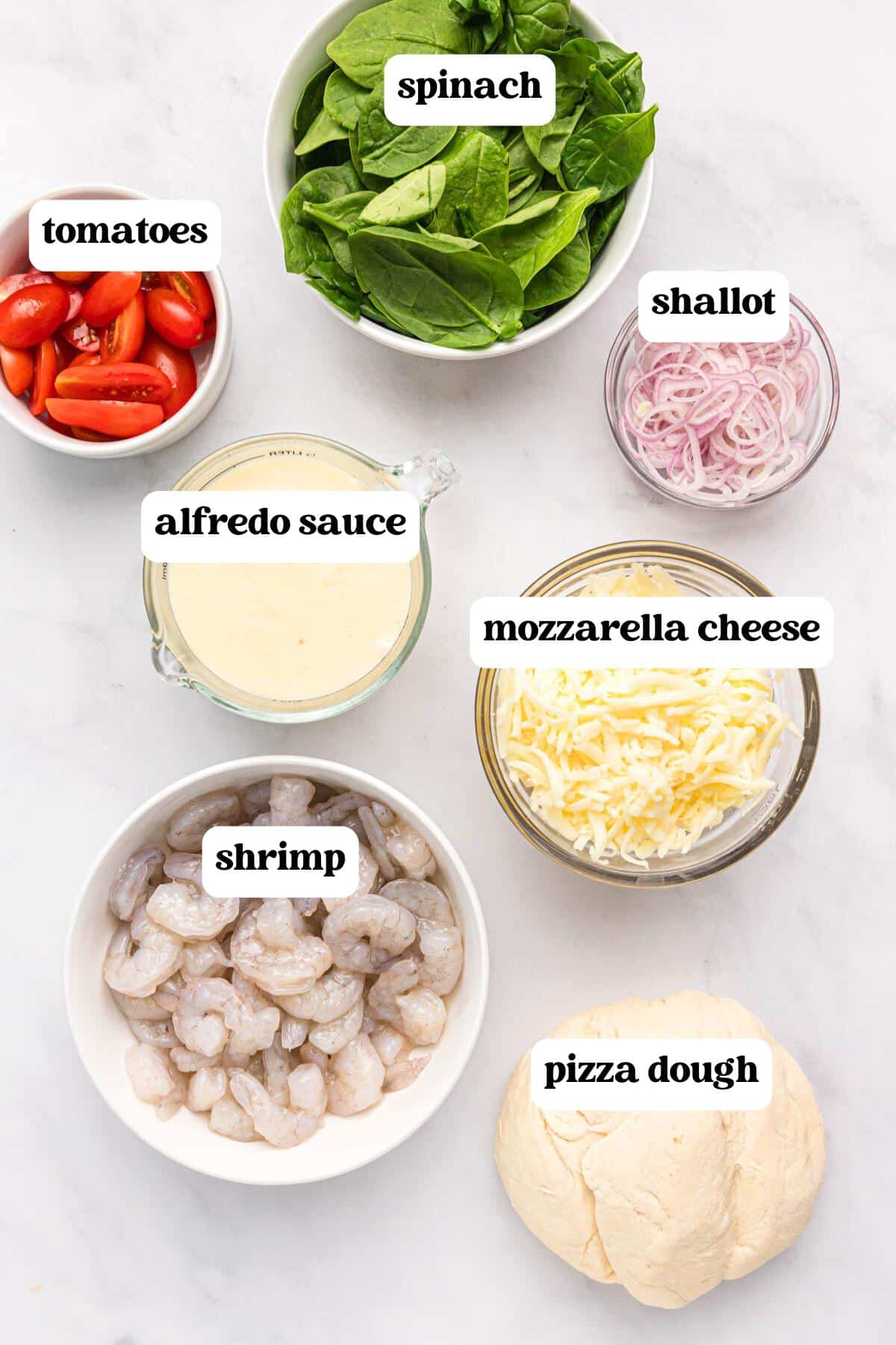 ingredients for shrimp alfredo pizza on a table