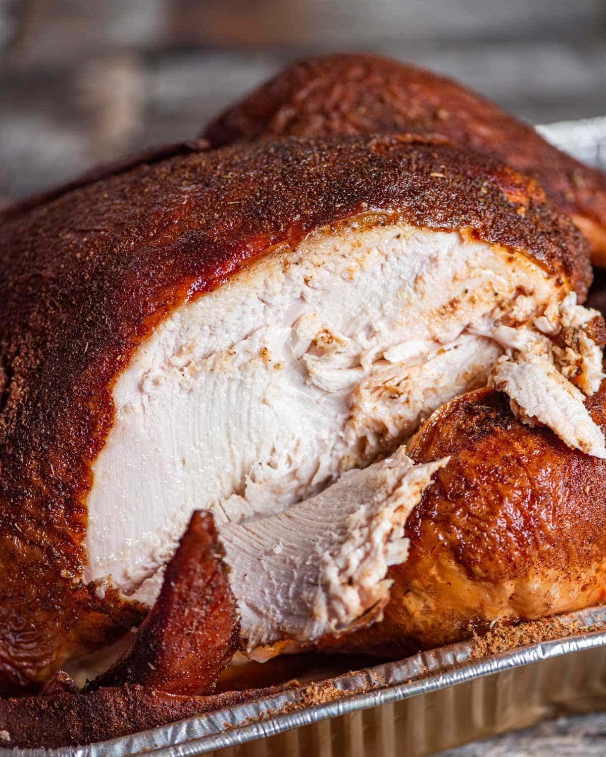 a smoked turkey with a slice cut out of the breast