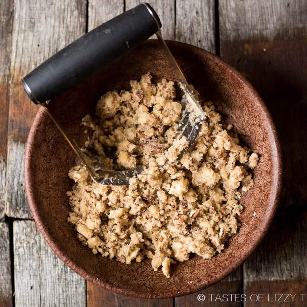 pecan streusel topping in a bowl with a pastry cutter