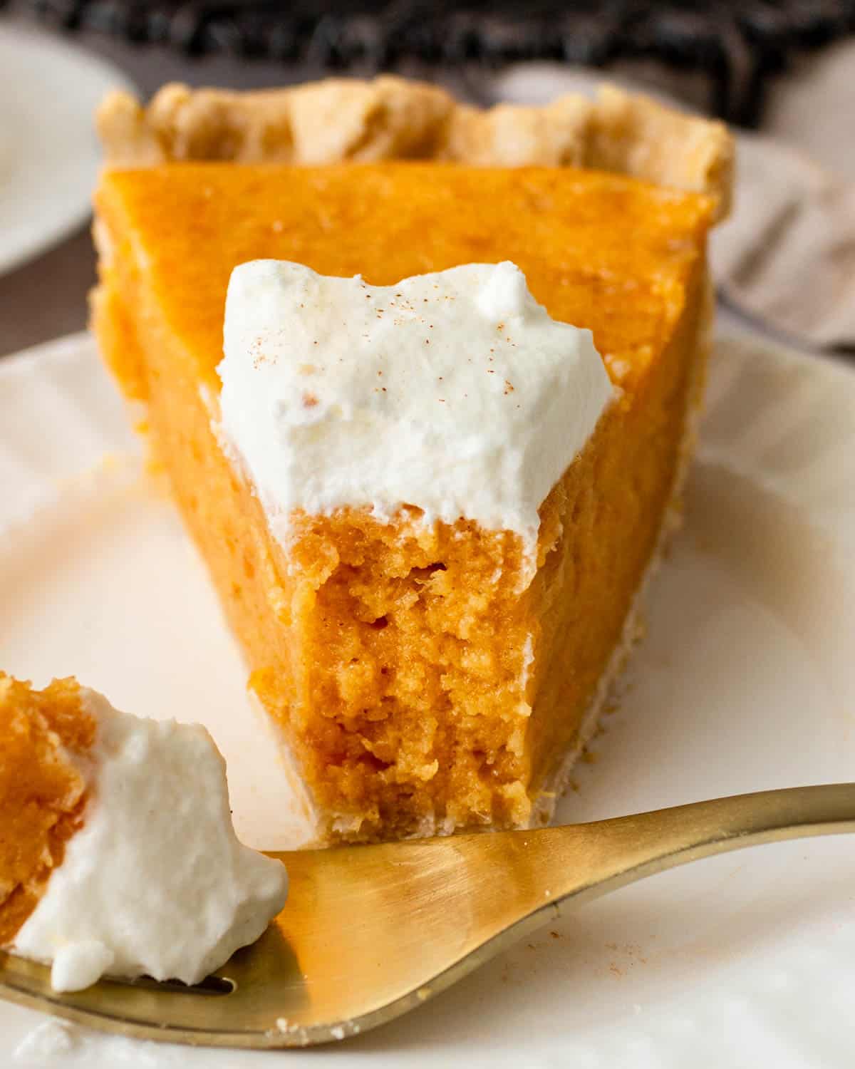 pie with whipped cream on a plate with a fork