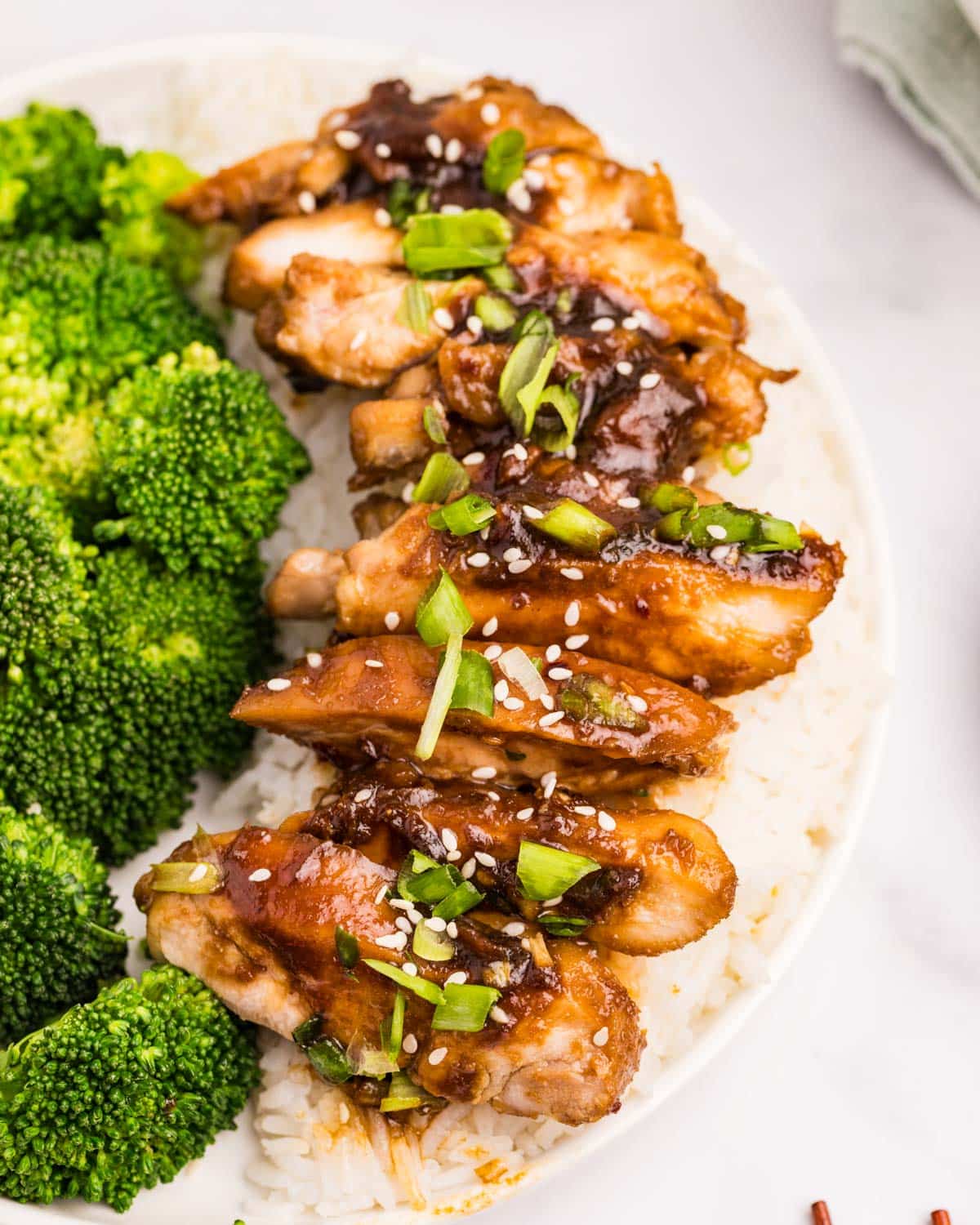 sliced teriyaki chicken on a plate with rice