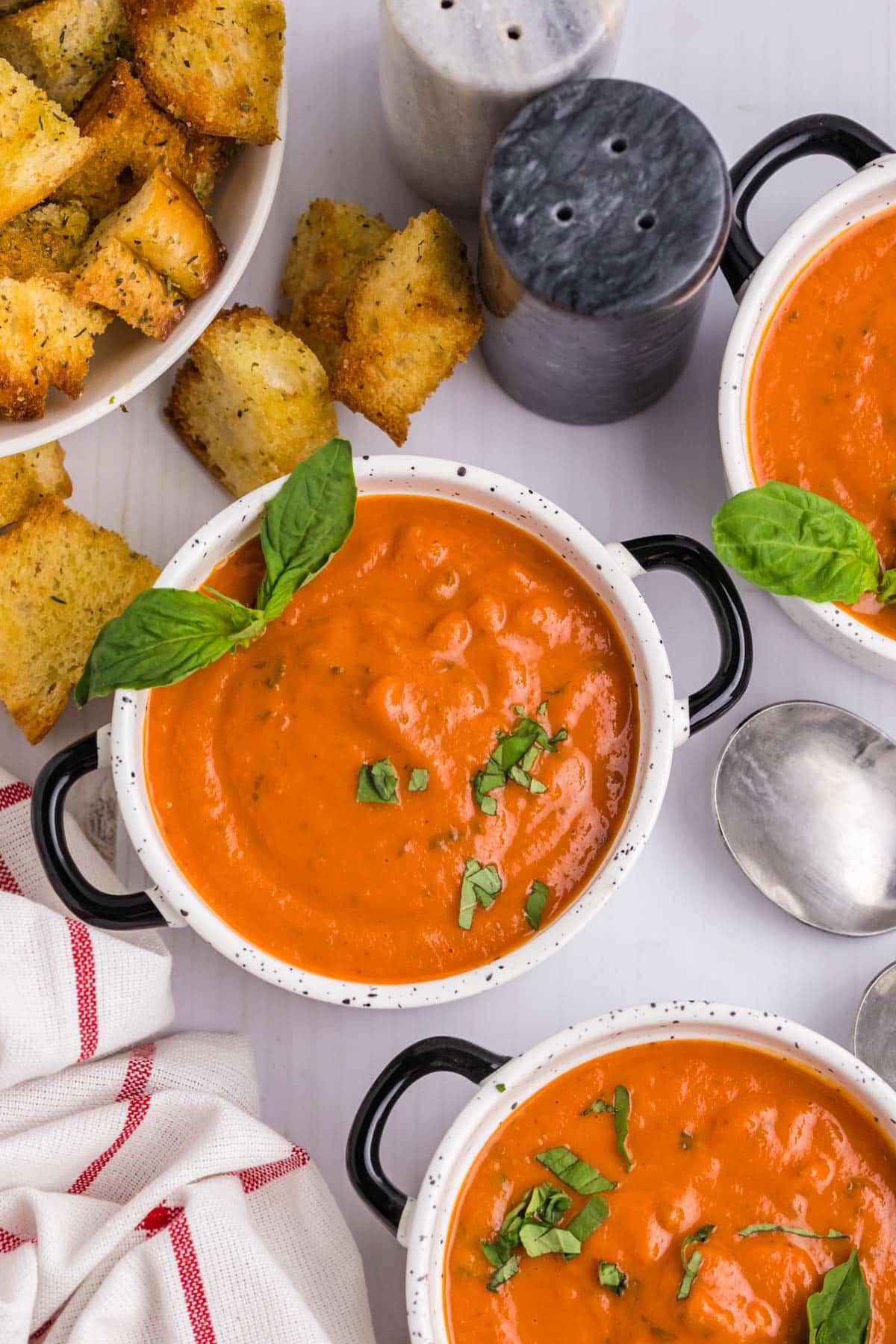 a table with tomato bisque soup in a little bowls