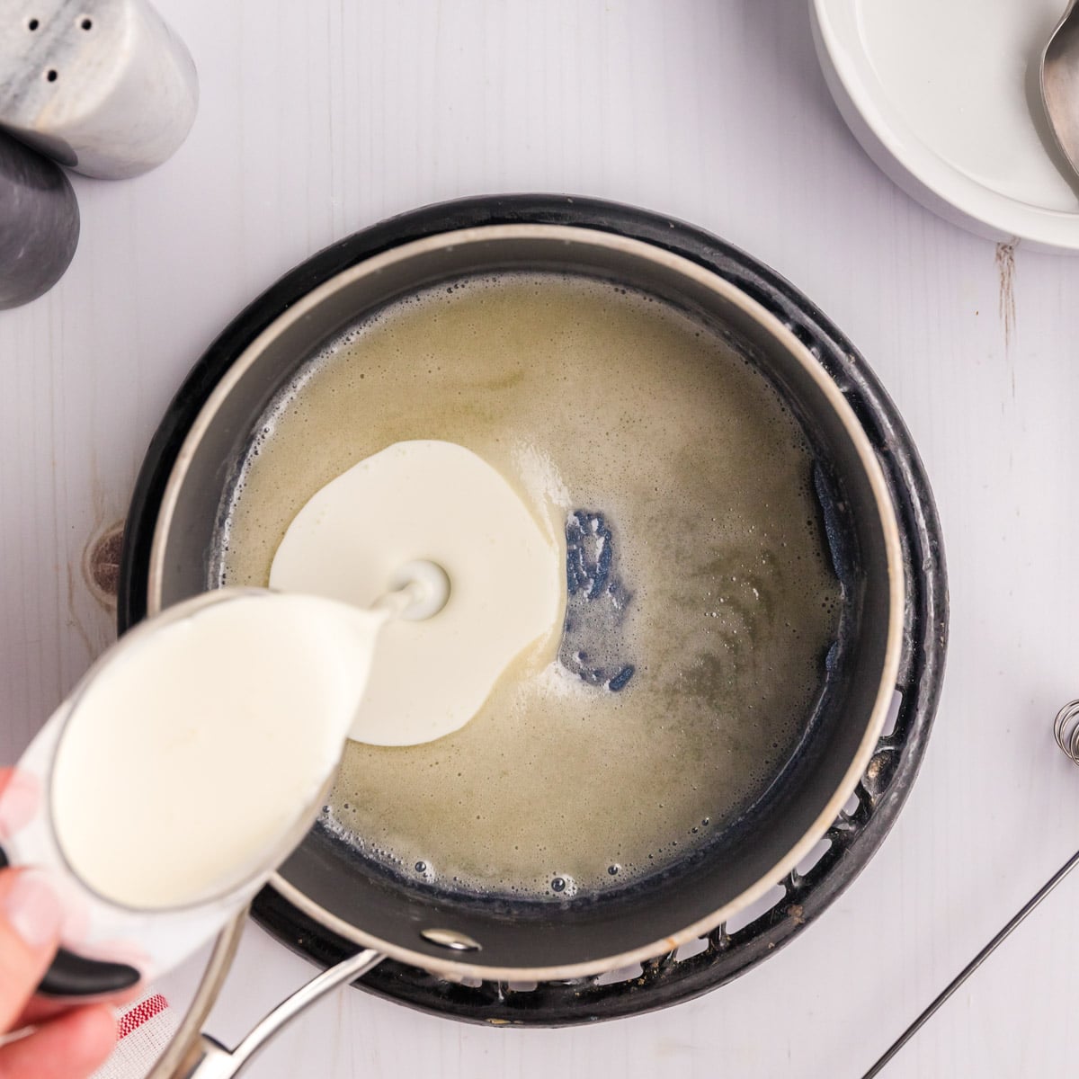 pouring cream into a butter roux