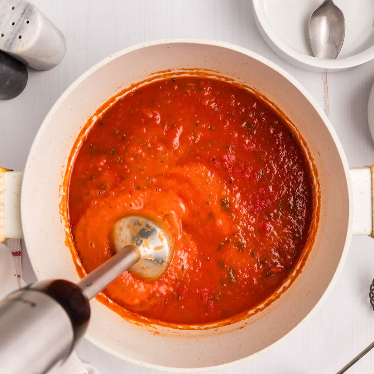 an immersion blender blending tomato soup