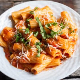 plate of tomato parmesan rigatoni with fresh basil