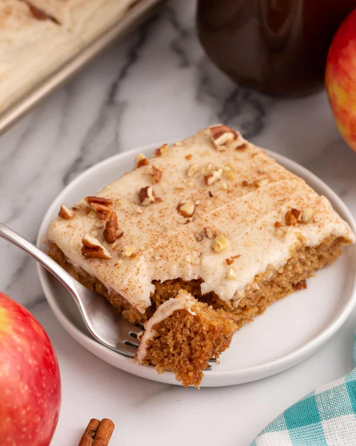 a piece of apple butter cake on a plate with a bite on a fork