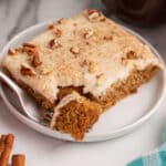 a piece of apple butter cake on a plate with a bite on a fork