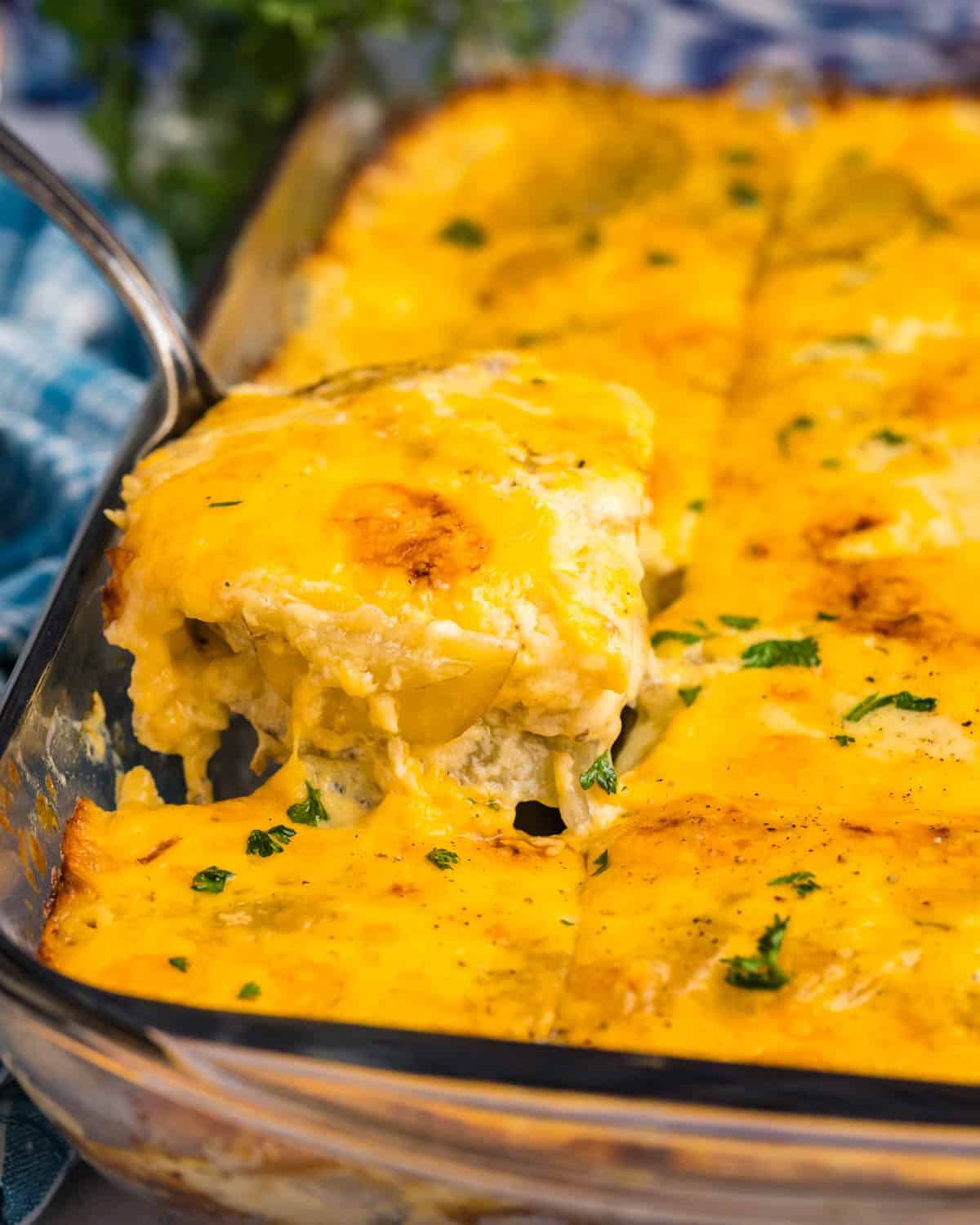 a spatula pulling out potatoes from a casserole