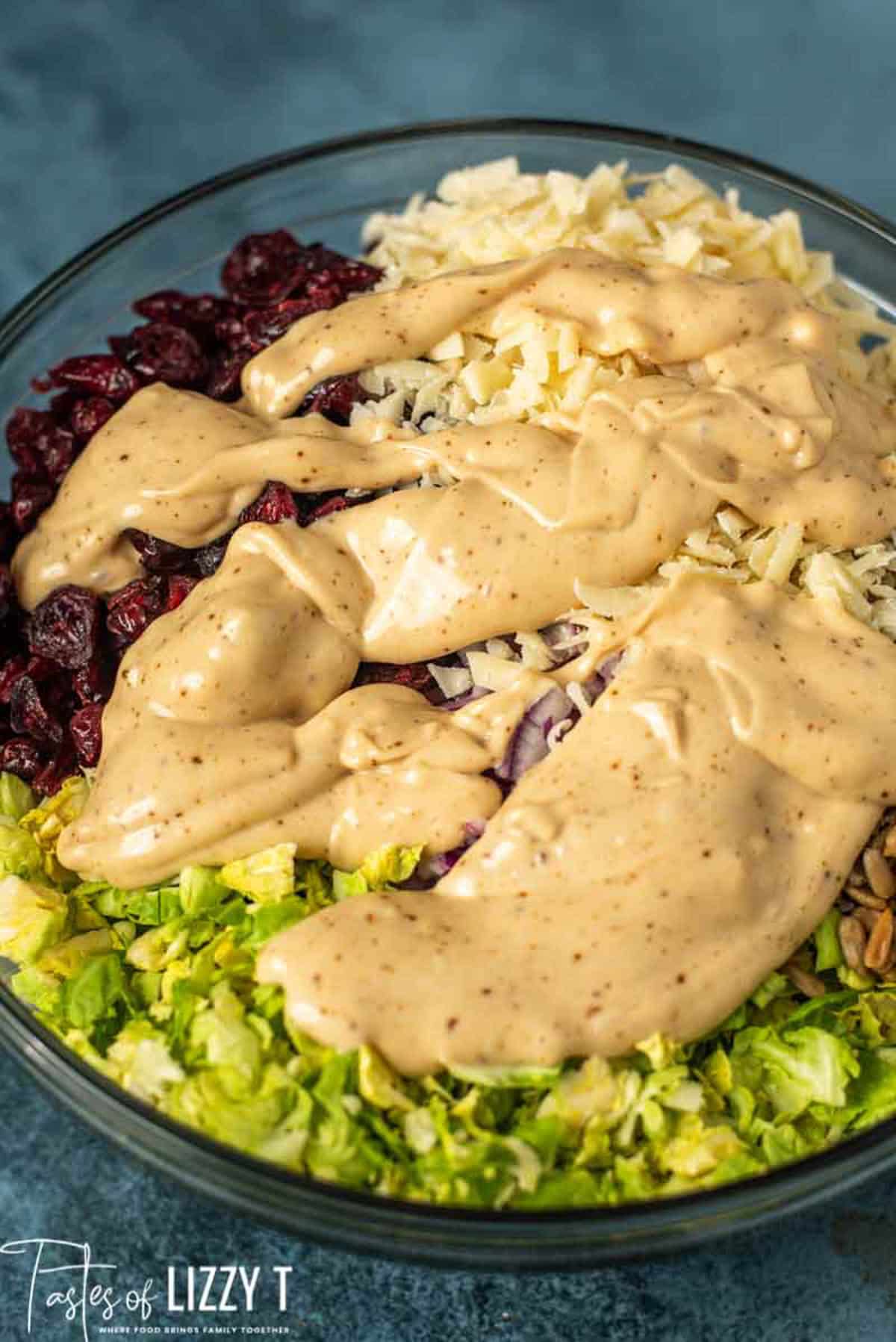 creamy dressing over brussels sprouts salad in a bowl