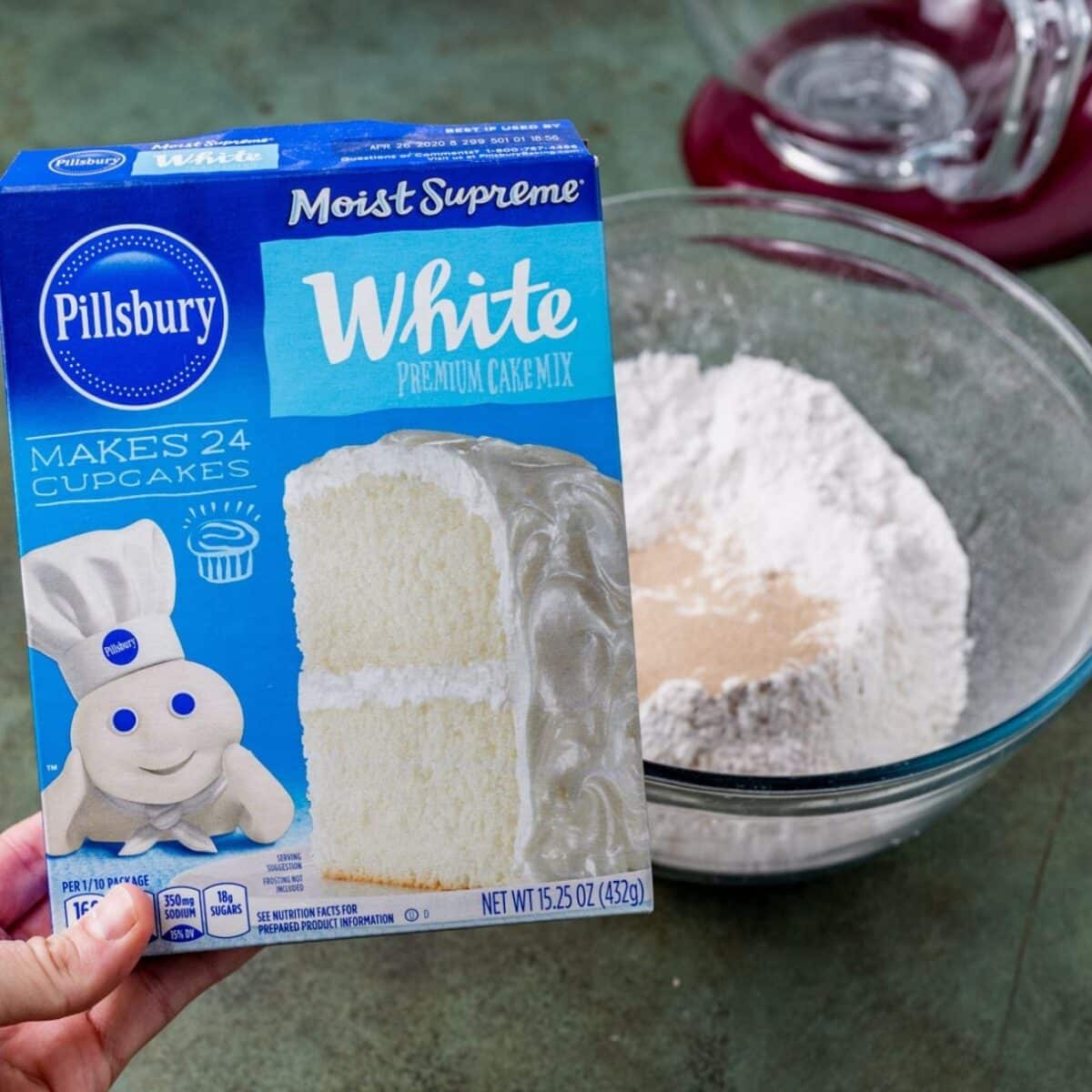 a box of white cake mix and a stand mixer