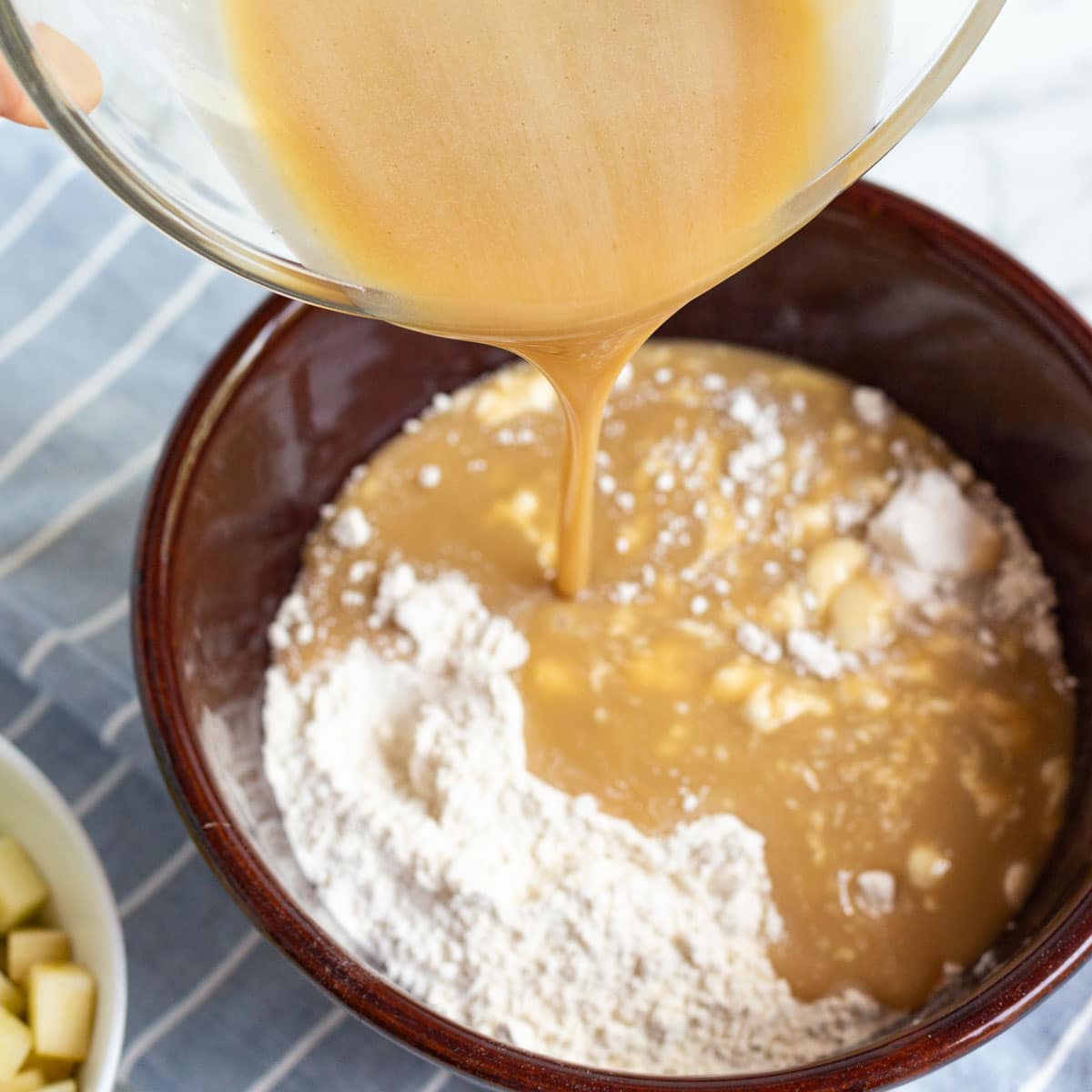 pouring egg mixture over dry ingredients in a bowl