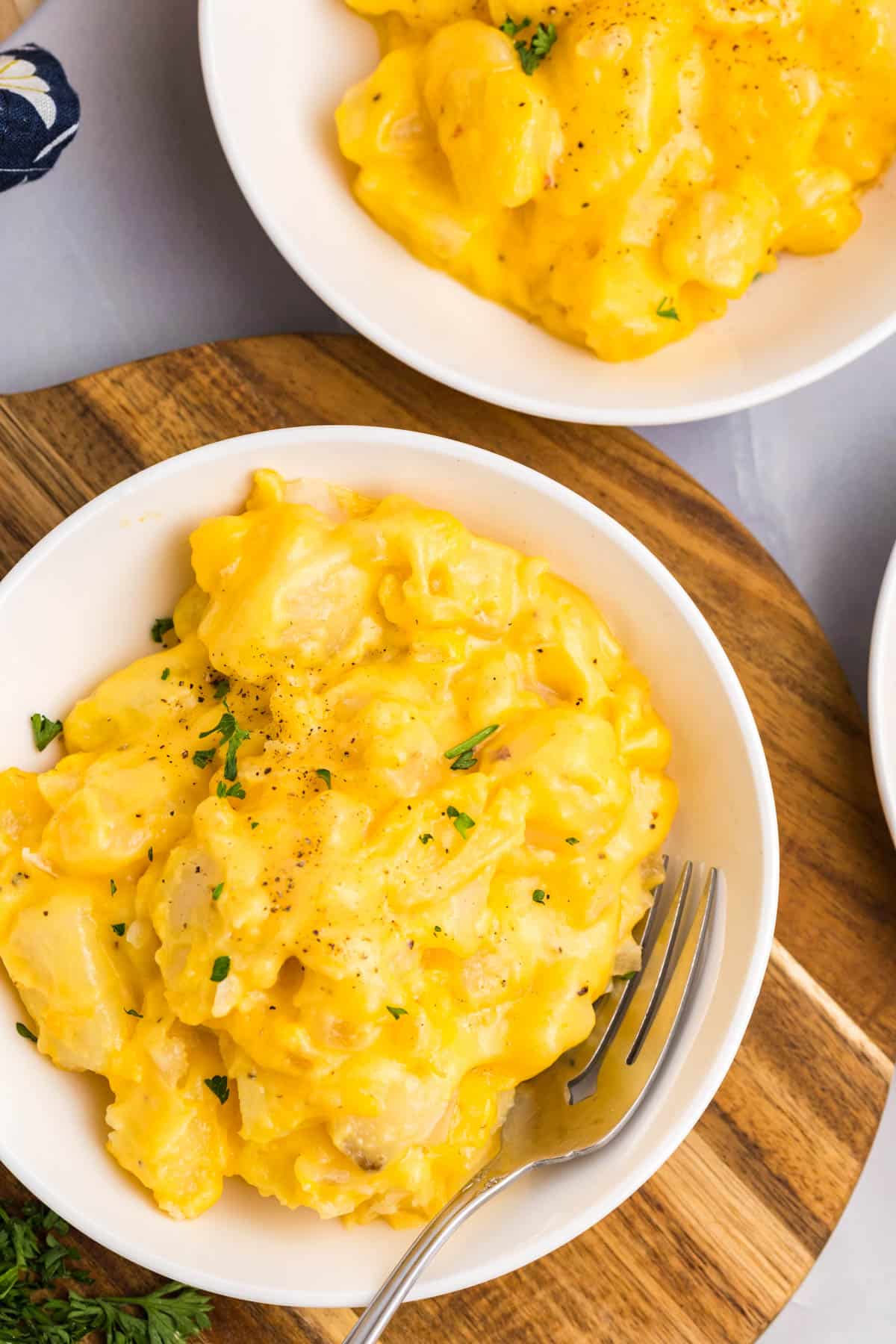 overhead view of two bowls of cheesy potatoes